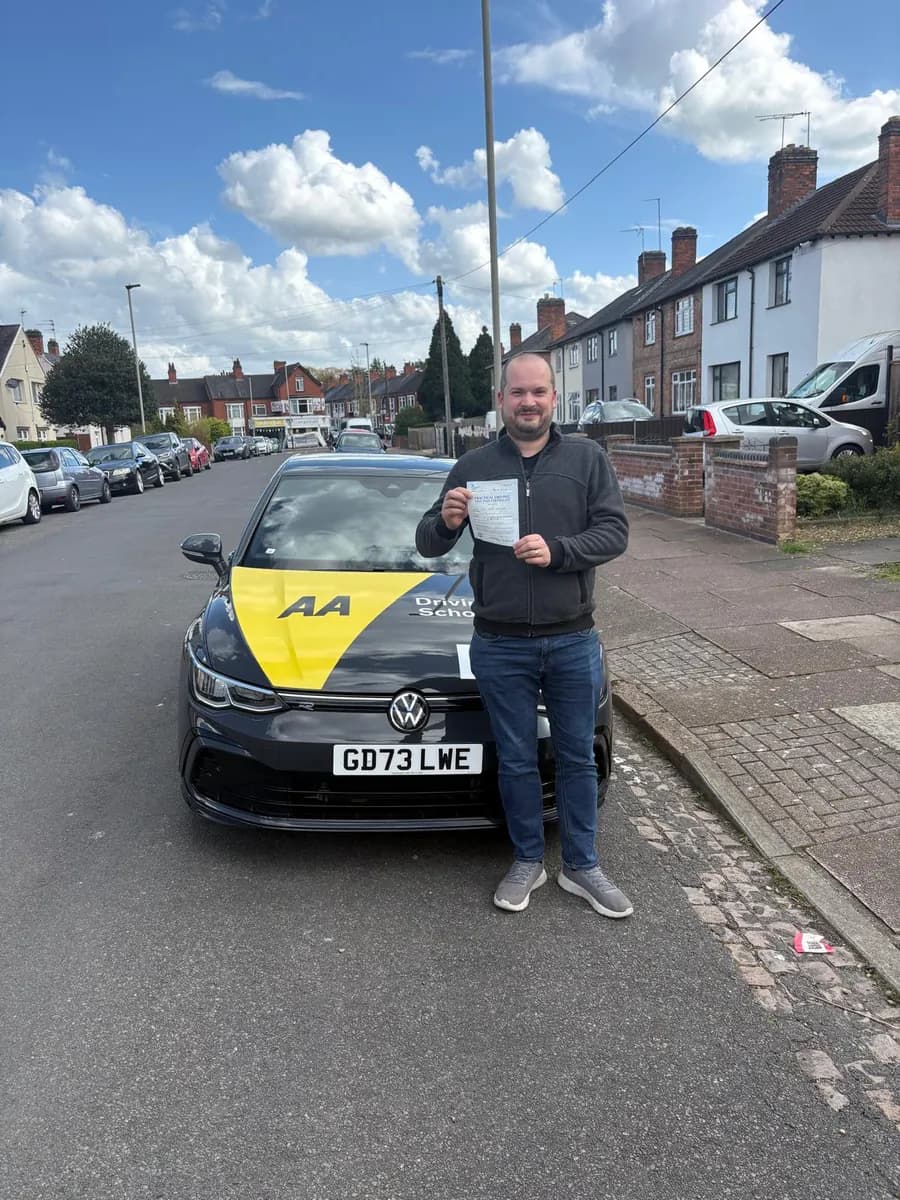 Lewis celebrating with his UK practical driving test pass certificate after lessons with DrivePro Midlands